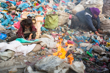 Criança com os pais em um lixão em Katmandu, Nepal